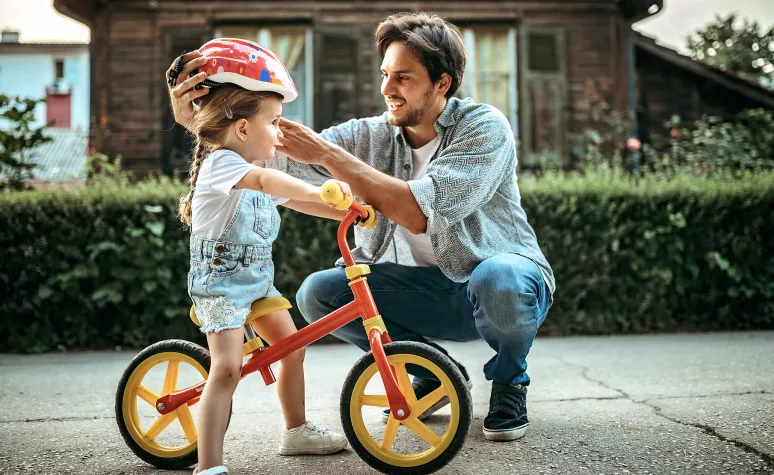 Father with daughter riding her bike